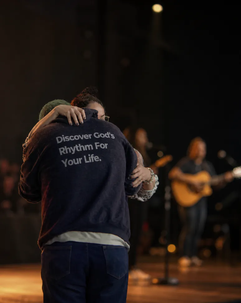 Two people embracing during worship at Rhythm Church