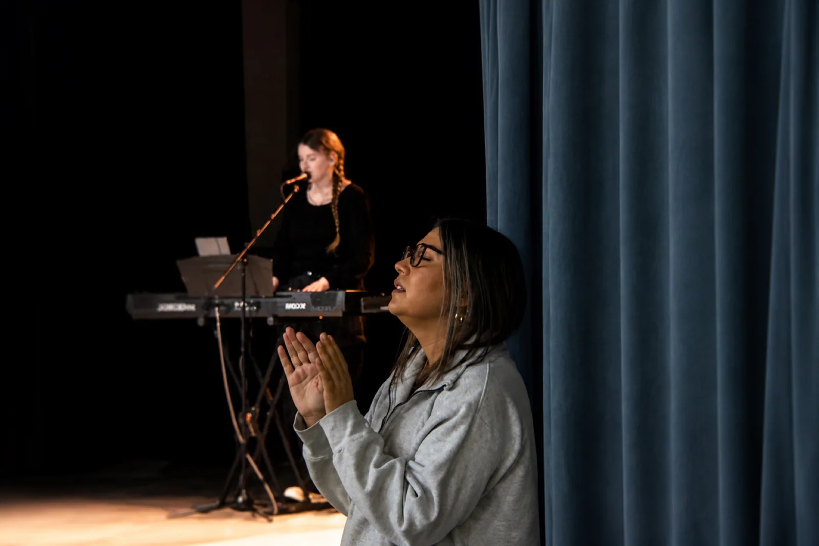 A person praying during worship at Rhythm Church